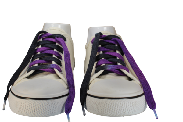 a pair of white sneakers with flat untied black and purple shoelaces