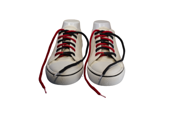 a pair of white sneakers with braided red and black custom dyed shoelaces