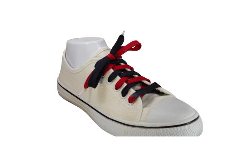 Black and red shoelace in a white shoe angled right