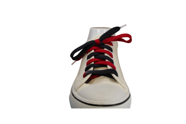 Single white shoe with a flat red and black shoelace