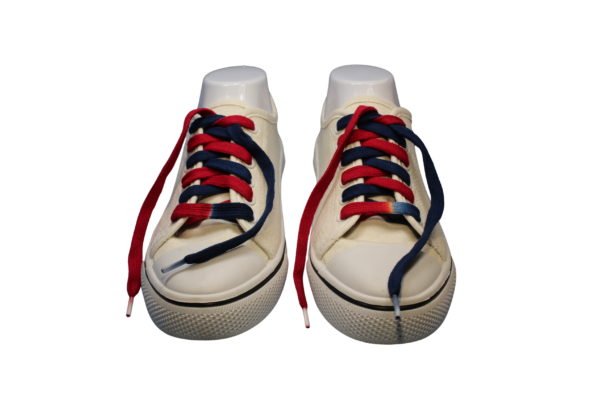 a pair of white sneakers with custom dyed navy blue and red untied shoelaces