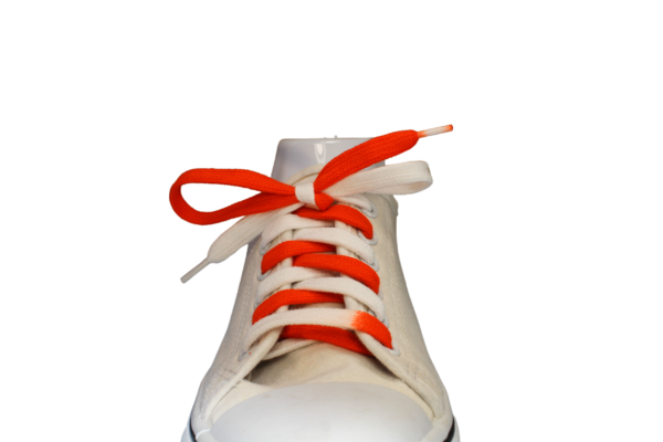 Orange and White flat tied shoelace in a white sneaker
