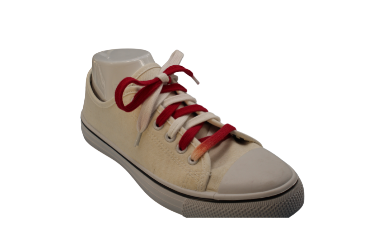 Red and white flat shoelaces in a shoe at an angle